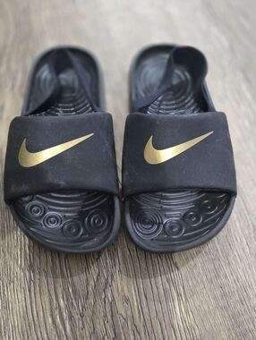 Nike Black Slides with Gold Swoosh Accent